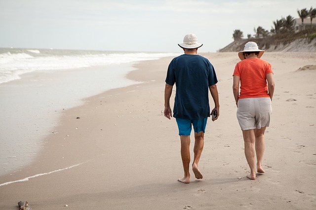 Un couple de senior marchant sur la plage