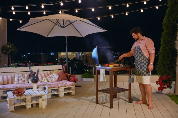 Un homme faisant un barbecue sur sa terrasse
