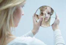 femme se regardant dans un miroir brisé